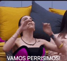 a woman in a purple dress is sitting on a couch with the words vamos perrisimos written above her