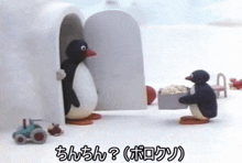 two penguins are standing next to each other in front of an igloo and one is holding a box of food .