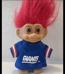 a troll doll with red hair is wearing a new york giants shirt