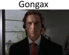 a man in a suit and tie is wearing headphones and the word gongax is above him