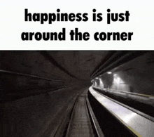 a train is going through a tunnel with the words `` happiness is just around the corner '' written on it .