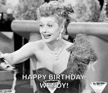 a black and white photo of a woman sitting at a table with a martini glass and the words `` happy birthday wendy '' .