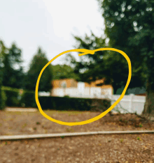 a yellow circle is drawn in front of a blurred house