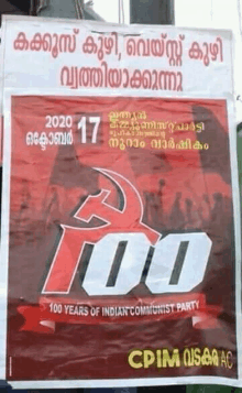 a red and white poster with a hammer and sickle on it is hanging on a pole .