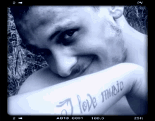 a man with a tattoo that says i love music on his arm