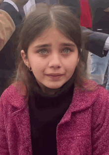 a young girl wearing a pink coat and black turtleneck