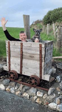 a man and his dog are sitting in a wooden cart