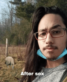 a man wearing glasses and a mask is standing in a field with a sheep in the background and the caption after sex