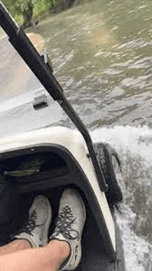 a person is riding a golf cart down a river .