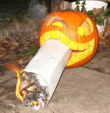 a pumpkin carved to look like a cigarette with smoke coming out of it