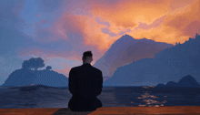 a man sits on a dock looking at a sunset over a body of water