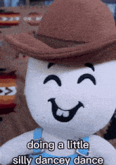a stuffed animal is wearing a cowboy hat and overalls and is doing a little silly dancey dance