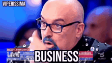 a bald man with glasses and a beard says business on the screen