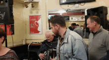 a man is playing an accordion in front of a sign that says ' irish cup festival ' on it