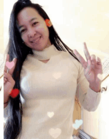 a woman with long hair is wearing a white sweater and giving the peace sign