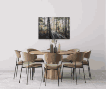 a dining room with a table and chairs and a painting on the wall above the table