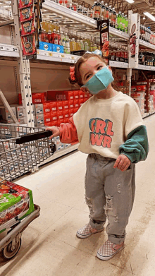 a little girl wearing a mask and a shirt that says girl pwr