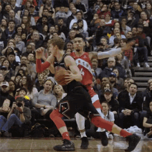 two basketball players are playing a game in front of a crowd and one of them has the number 4 on his jersey