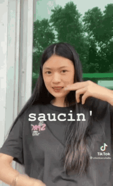 a girl wearing a black shirt that says saucin