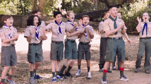 a group of boy scouts are standing in a line and one of them has the letter r on his shirt