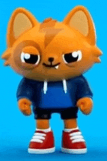 a toy cat is wearing a blue hoodie and red sneakers .