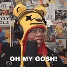 a woman with red hair is wearing a winnie the pooh hat and headphones .