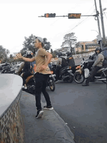 a man stands on a sidewalk in front of a traffic light with a sign that says ' jakarta '