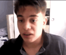 a close up of a young man 's face with a black shirt