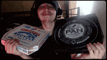 a man is holding a pizza box that says pan