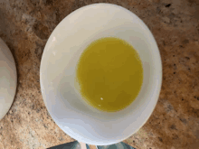 a small white bowl filled with a yellow liquid