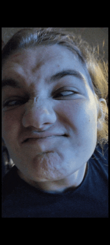 a close up of a person 's face with a black shirt on