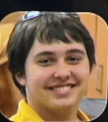 a close up of a person 's face with a yellow shirt