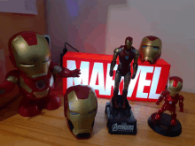 a group of iron man toys are on a table in front of a marvel box