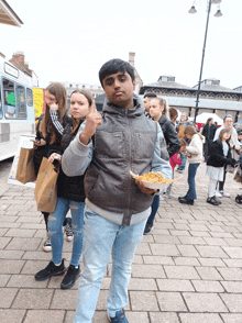 a man holding a plate of food in front of a sign that says ' ice cream ' on it