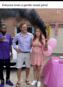 a girl in a pink dress is holding a black smoke bomb at a gender reveal