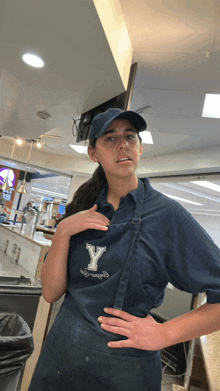 a woman wearing a blue apron with a letter y on it