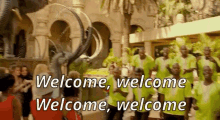 a group of people standing in front of a building with the words welcome welcome welcome welcome written on it