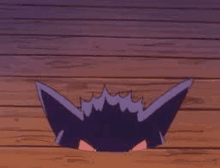 a purple cartoon character is sticking its head out of a hole in a wooden floor .