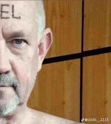 a shirtless man with a beard has the word jesus written on his forehead .