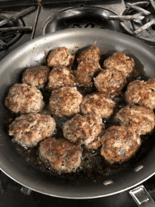 meatballs are being cooked in a skillet on a stove