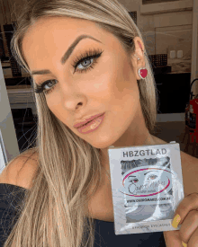 a woman holds up a package of hbzgtlad eyelashes