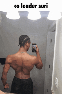 a man is taking a picture of his back in a bathroom mirror with the caption co leader suri