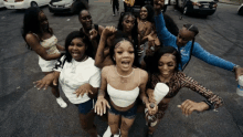 a group of women are standing in a parking lot and one of them is holding a cup that says ' pepsi ' on it