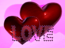 two red hearts with the word love written on them on a pink background