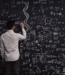 a man stands in front of a blackboard with a lot of math equations on it