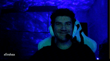 a man wearing headphones and a microphone in a dark room with xfirehex written in the corner