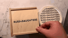 a person is holding a wooden box that says russ & daughters on it