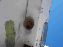 a close up of a piece of metal with a hole in it and a blue background