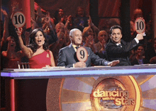 a dancing with the stars judge holds up a sign with the number 10 on it