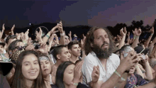 a crowd of people at a concert with one man wearing a wristband that says ' i love you '